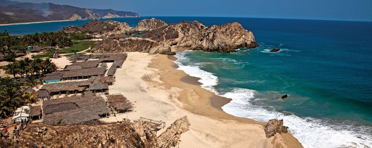 ¿Por Qué las Playas de Michoacán No Son Famosas? Las playas de Michoacán son un verdadero tesoro escondido de la costa del Pacífico mexicano, con paisajes vírgenes, arenas doradas y un ambiente tranquilo que contrasta con los bulliciosos destinos turísticos como Cancún o Puerto Vallarta. Sin embargo, a pesar de su innegable belleza, las playas de Michoacán no son famosas en comparación con otros destinos turísticos de playa en México. Existen diversas razones que explican por qué estas joyas naturales han permanecido en el anonimato, a pesar de su potencial. Infraestructura Turística Limitada Una de las principales razones por las que las playas de Michoacán no son famosas es la falta de infraestructura turística desarrollada. A diferencia de otros estados, como Quintana Roo o Baja California, Michoacán no cuenta con un sistema de hoteles de lujo, resorts todo incluido o aeropuertos internacionales cercanos que faciliten la llegada masiva de turistas. Las carreteras que conectan a las playas, aunque han mejorado en los últimos años, siguen siendo menos accesibles y pueden ser un desafío para quienes no están acostumbrados a conducir largas distancias por zonas rurales. Percepción de Seguridad Otro factor importante es la percepción de seguridad en el estado. Michoacán ha tenido una reputación desfavorable debido a los problemas de violencia relacionados con el narcotráfico. Aunque muchas de las zonas costeras y turísticas son seguras, la percepción negativa ha influido en la decisión de muchos turistas de no aventurarse a esta región. Esta imagen ha frenado la promoción del estado como un destino turístico de primer nivel, limitando el número de visitantes que podrían descubrir sus playas. Falta de Promoción Turística A diferencia de destinos como Cancún, Los Cabos o Puerto Vallarta, que cuentan con campañas de marketing intensivas a nivel nacional e internacional, las playas de Michoacán no han sido suficientemente promovidas. El estado ha sido más conocido por su riqueza cultural, como la celebración de la Noche de Muertos en Pátzcuaro o su artesanía purépecha, pero las playas no han recibido la misma atención. Sin la visibilidad adecuada en los medios de comunicación y en las plataformas turísticas, las playas de Michoacán han permanecido en el anonimato para muchos viajeros. Un Destino Más Natural y Rústico Las playas de Michoacán ofrecen un ambiente más natural y rústico, lo que puede ser menos atractivo para el turismo de masas que busca comodidades modernas y entretenimiento constante. Mientras que destinos más populares ofrecen grandes infraestructuras turísticas, entretenimiento nocturno y actividades acuáticas organizadas, las playas michoacanas se destacan por su tranquilidad, naturaleza virgen y la posibilidad de disfrutar de una experiencia más auténtica y sin multitudes. Esto puede atraer a viajeros aventureros y ecoturistas, pero no necesariamente a aquellos que buscan las comodidades de un resort. Falta de Conexiones Internacionales Otro factor que contribuye a que las playas de Michoacán no sean famosas es la limitada conectividad internacional. Los aeropuertos más cercanos, como el de Lázaro Cárdenas o Uruapan, no cuentan con vuelos directos desde grandes ciudades internacionales, lo que hace que llegar a las playas del estado sea más complicado para los turistas extranjeros. En comparación, destinos como Cancún o Los Cabos tienen una amplia gama de vuelos internacionales que permiten un acceso mucho más sencillo y directo. El Potencial de las Playas de Michoacán A pesar de estos desafíos, las playas de Michoacán tienen un enorme potencial para convertirse en un destino turístico destacado en el futuro. Playas como Maruata, Faro de Bucerías y Colola son conocidas por su belleza virgen y por ser refugios importantes para las tortugas marinas. Además, su relativo anonimato podría ser un atractivo para los turistas que buscan alejarse de las multitudes y disfrutar de una experiencia más tranquila y auténtica. El ecoturismo, por ejemplo, podría ser un motor clave para el desarrollo de la costa michoacana, especialmente si se realizan esfuerzos por mejorar la infraestructura sin comprometer el entorno natural. De igual forma, si las autoridades locales y estatales logran cambiar la percepción de seguridad y se enfocan en promocionar las playas como un destino turístico sostenible, Michoacán podría convertirse en un imán para los amantes de la naturaleza y el turismo responsable. En resumen, aunque las playas de Michoacán no son tan famosas como otras en México, esto se debe a factores como la falta de infraestructura turística, la percepción de seguridad y la limitada promoción. No obstante, para aquellos que se aventuran a visitarlas, ofrecen una experiencia única y auténtica que no se encuentra en los destinos más comerciales del país.